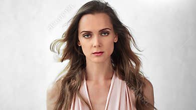 Adorable fashion model with curly hairstyle go on light backdrop. Shot on RED Raven 4k Cinema Camera