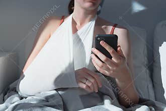 Wounded arm in bondage, woman rests in  bed, body parts.