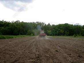 Plowed field by tractor in brown soil on open countryside nature