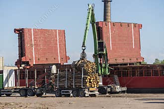 The cargo ship is loaded with firewood from the truck