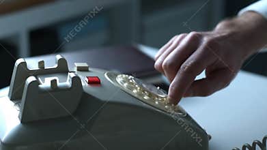 Businessman dialing a number on a vintage phone