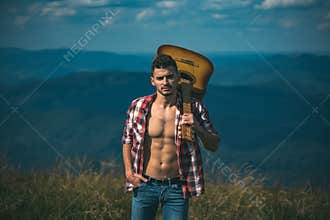 Hiking man. Motivated hiker with guitar looking at beautiful view. Trekking, travel and tourism concept. Fitness and