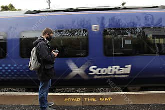 Man Standing on Platform by Moving Train