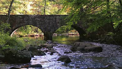 Double Arch stone bridge over gently flowing Flatbrook River in Stokes State Forest, NJ, in fall