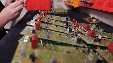 Hands inserting electronic component into printed circuit board