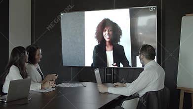 African American partner greeting colleagues via video c