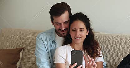 Couple relaxing on sofa using smartphone enjoy internet entertainment
