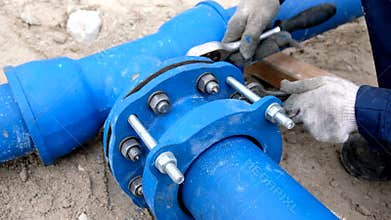 Workers installing water supply pipeline system, close up