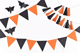 Halloween background with garlands and paper bats in traditional colors orange and black on white background