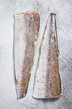 Raw fillet of hake fish. White background. Top view
