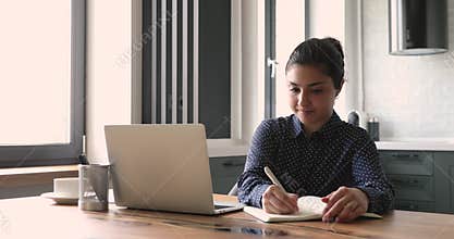 Businesswoman search information on internet writes it in personal organizer