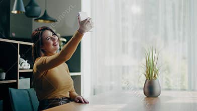 Beautiful woman take selfie in apartment .