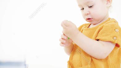 Blonde baby girl taking color pencils out of her pocket