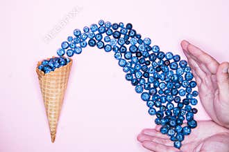 Fresh blueberries in ice cream cone on a pink background. Blueberry Blast. Summer vacation concept. Flat lay, top view. The style