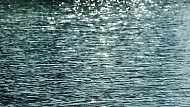 Smoky and white Bokeh sun glare reflected in water surface. flickering in water Abstract blurry out of focus bokeh