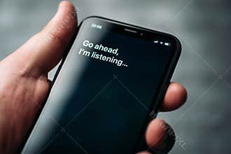 Moscow, Russia - Circa August 2019 : Iphone and activated by voice Apple digital assistant Siri and text: Go ahead, I`m listening