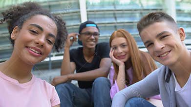 Cheerful multiethnic teen friends smiling at camera, leisure time together