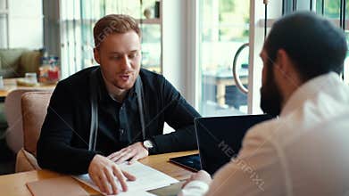 Candidate for job presents himself to employer in relaxed cafe environment.