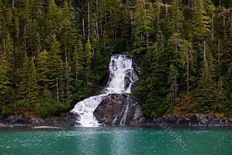 Beautiful flowing waterfall into the ocean in Endicott Arm, Alaska