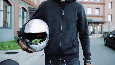 Biker goes to his cool and custom motorcycle in a big city