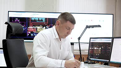 Dispatcher is working in control room of engineering systems in energy industry.