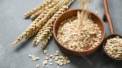 Oat flakes or rolled oats falling in bowl