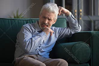 Upset bereaved old man widower mourning crying alone at home