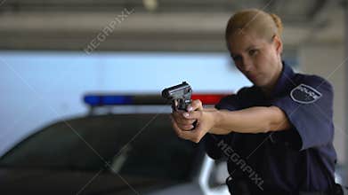 Female police officer aiming gun into criminal, dangerous work, crime prevention