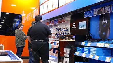 Motion of people playing VR game and worker explains how to operate the game inside the store