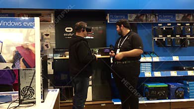 Motion of people playing VR game and worker explains how to operate the game inside the store