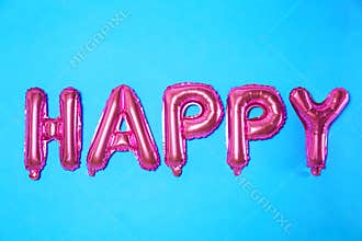 Word HAPPY made of pink foil balloon letters on blue background