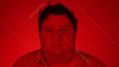 Portrait nervous afraid stressed young man feels awkward looking away sideway anxiously craving something. Red lighting