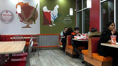 Motion of people enjoy a meal inside Popeyes chicken restaurant