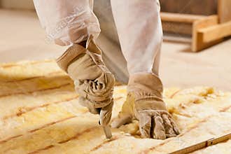 Man cutting insulation material for building