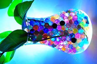 Illuminated jar with colourful balls & water plant