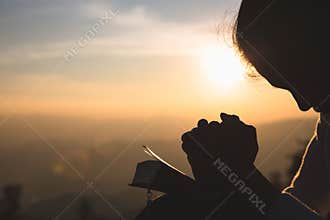 Woman praying in the morning on the sunrise background. Christianity concept. Pray background. Faith hope love concept