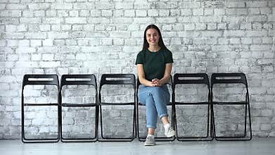 Happy confident female applicant looking at camera sit on chairs
