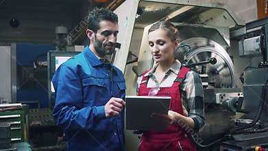 Woman and man manufacturing worker in discussion
