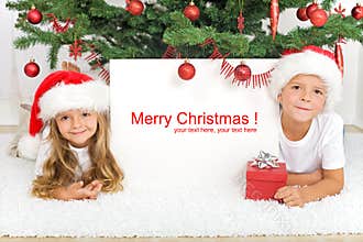 Kids laying under the christmas tree