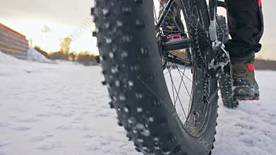 Professional extreme sportsman biker riding fat bike in outdoor. Close-up view of rear wheel. Cyclist ride in winter