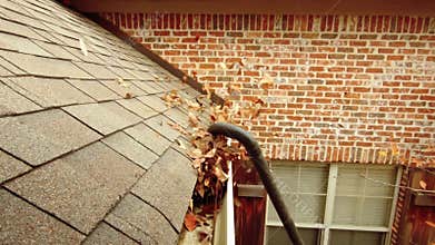 Gutter clogged with leaves being cleaned out, slow motion