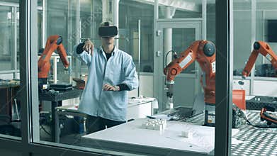 Male researcher wearing VR-glasses in a laboratory with a robot