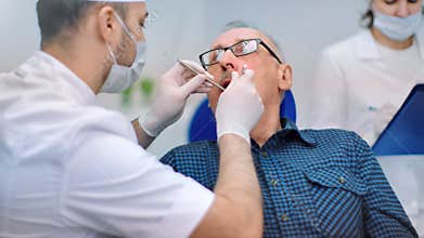 Professional doctor checking condition teeth of senior client dental clinic. 4k Dragon RED camera