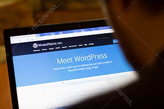 New York, USA - 9 April 2020: WordPress website on laptop screen close up. Man using service on display, blurry background,