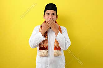 In Ramadan Kareem Young Asian Muslim Man try to keep his mouth to do not speak useful things in fasting, His mouth covered by his