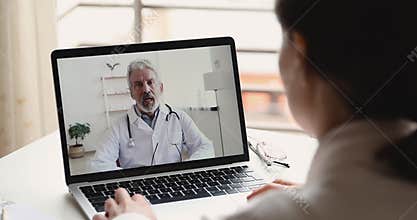 Senior doctor videoconferencing remote patient during telemedicine video call