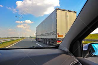 Car speeding over a truck on a highway