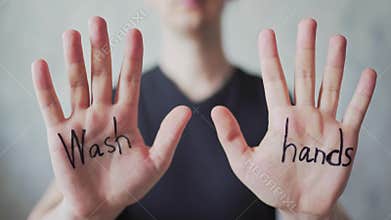 Text - wash hands, written on men`s hands. Protection from the Covid-19 virus. The concept of coronavirus and pandemic