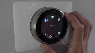 Man adjusting smart thermostat gadget at home