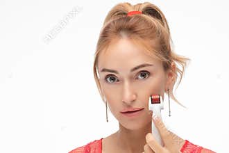Woman with microneedle mesotherapy roller. Isolate on white.
